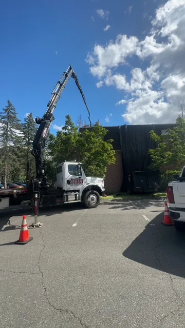 Commercial roof tear-off with boom-crane truck on site — Ultimate Roofing