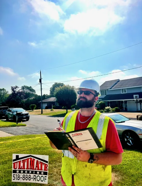 Ultimate Roofing estimator performing a free roof inspection with clipboard and hard hat — Capital Region NY